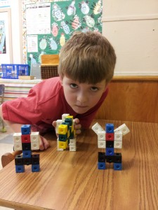 Ollie with three version of Optimus Prime made out of snap cubes!